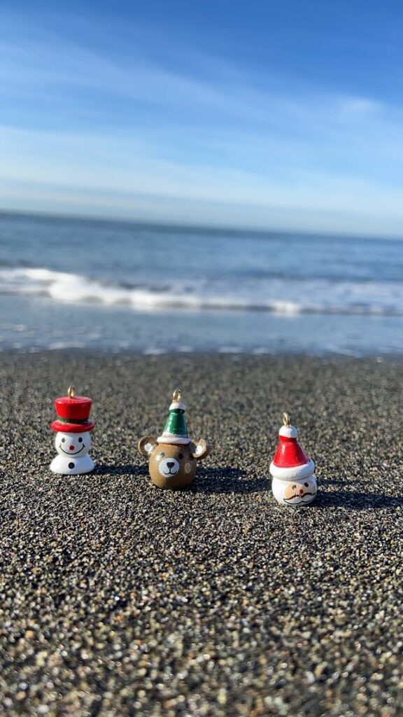 hiekkarannalla kolme pientä joulukoristetta